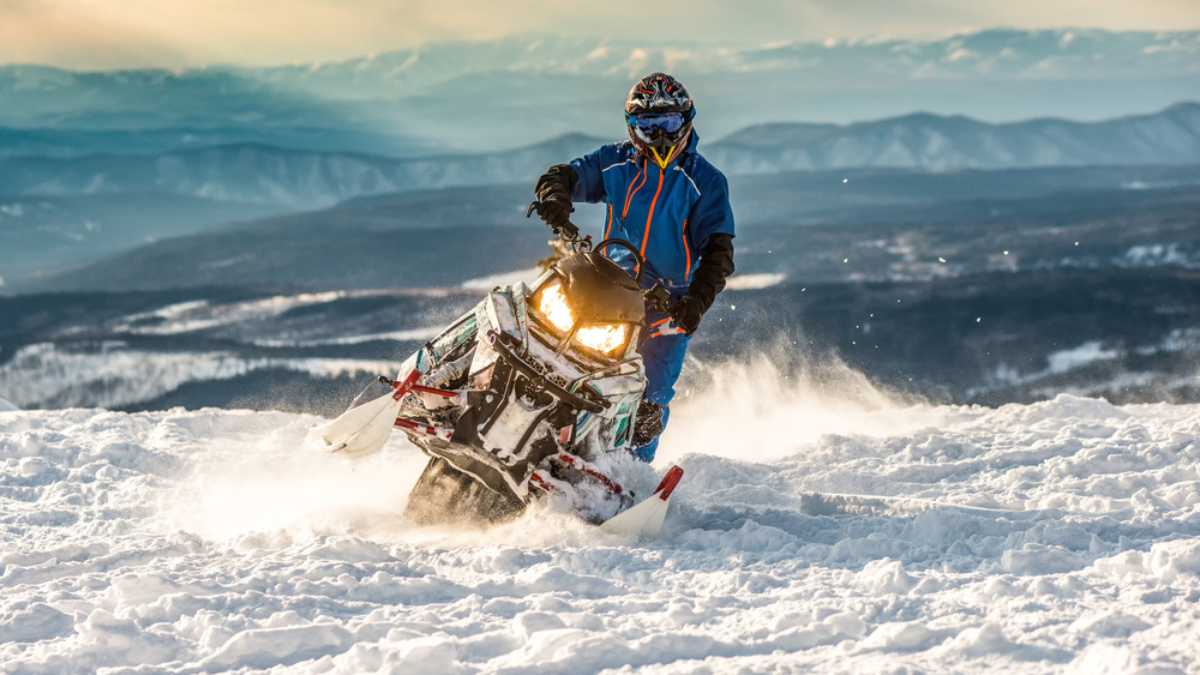 Rider on the snowmobile in the mountains ski resort in Amut Russia.