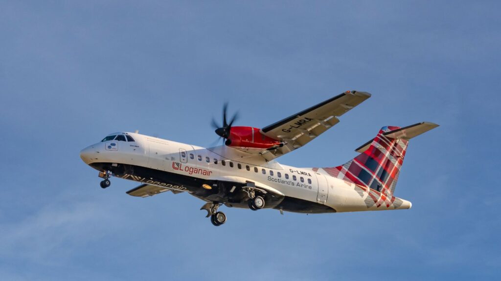 Scotlands Turboprop regional Airline, Logan Air, flys in the ATR 42 Turboprop aircraft against a clear bright late afternoon blue sky