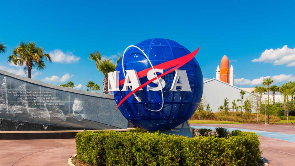 Cape Canaveral, FL, USA - April 1, 2015: NASA Logo on Globe at Kennedy Space Center Visitor Complex in Cape Canaveral, Florida, USA. To the left is a painting visible of President John F. Kennedy.