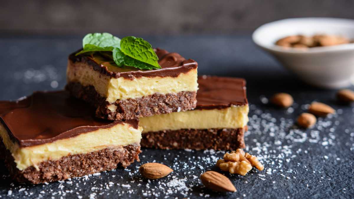 Nanaimo bars - traditional Canadian dessert with wafer crumbs, almond, walnut and cocoa layer, vanilla custard filling and chocolate topping