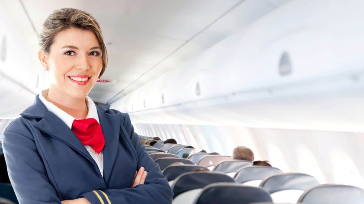 Beautiful air hostess in an airplane smiling