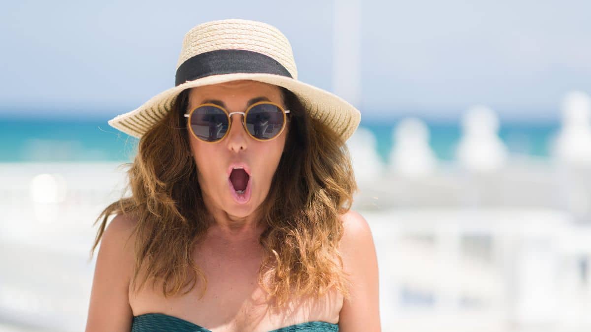 woman in hat surprised on beach