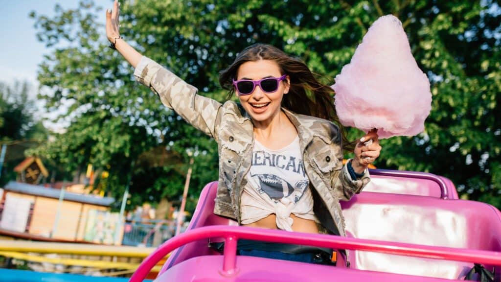 woman on roller coaster holding cotton candy