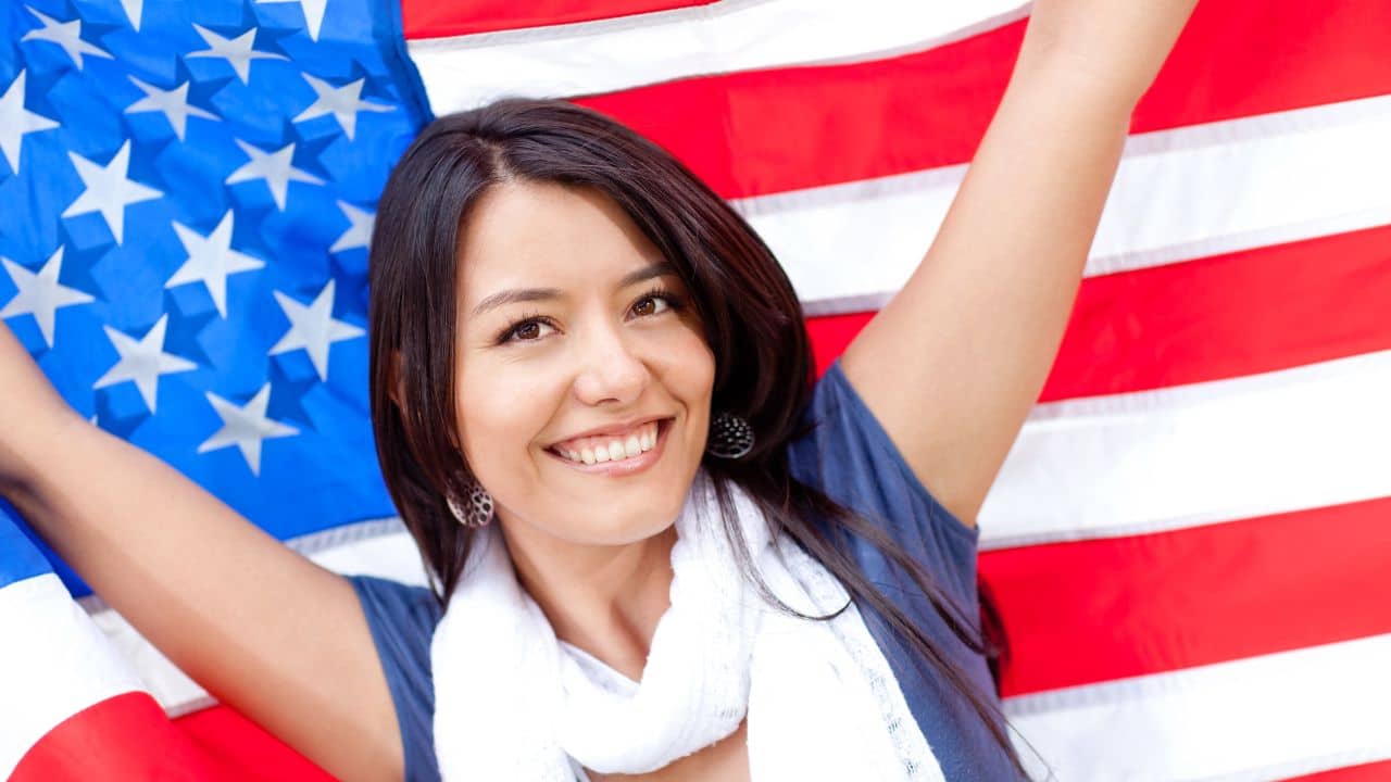 Proud woman with the American flag and smiling