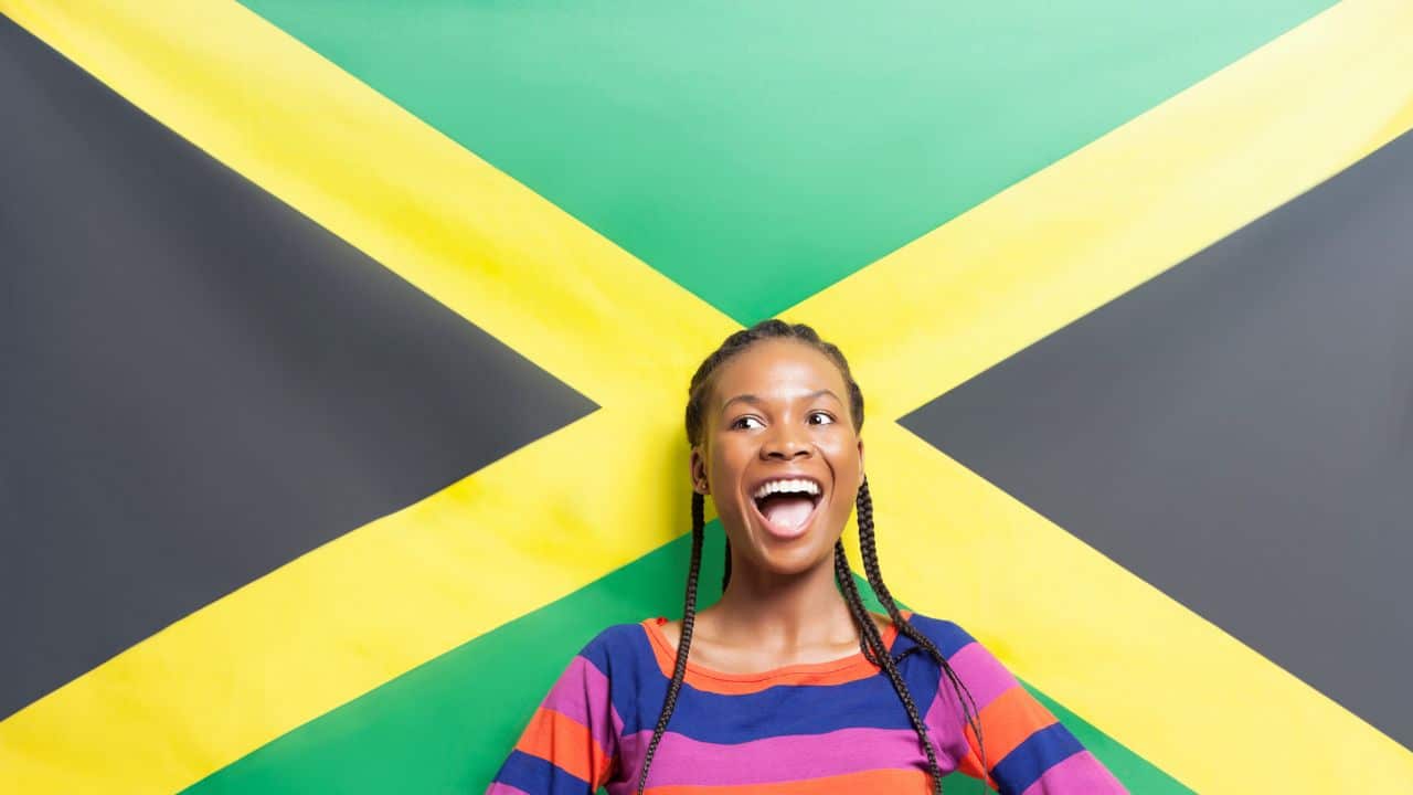 Young excited woman against Jamaican flag