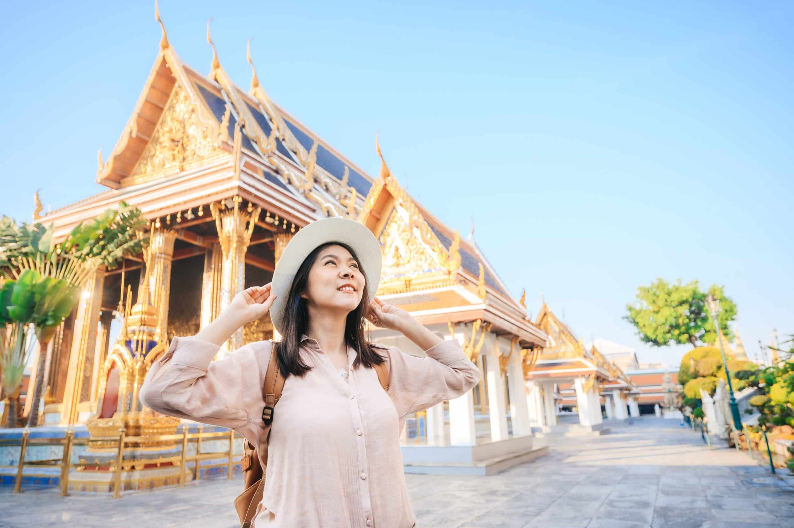 Tourist woman enjoy travel in temple of the emerald buddha, Wat Phra Kaew, popular tourist place in Bangkok, Thailand